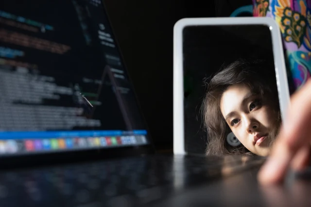 Chenchen Zheng reflected beside a laptop, an authentic personal photograph.